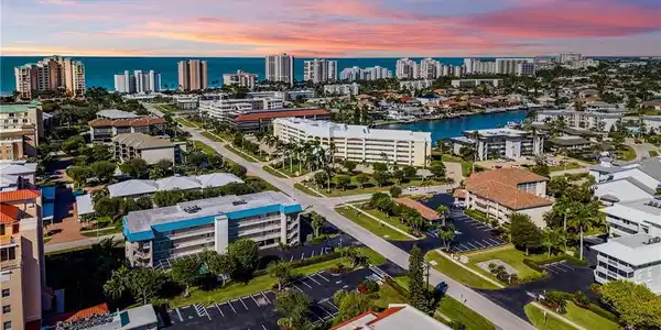 Image 2: Coastal urban landscape featuring high-rise buildings, a central waterway, and established residential areas