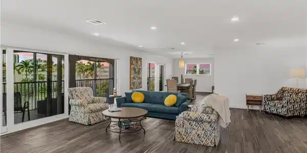 Image 4: Expansive living area with wood-finish flooring, recessed lighting, and crown molding
