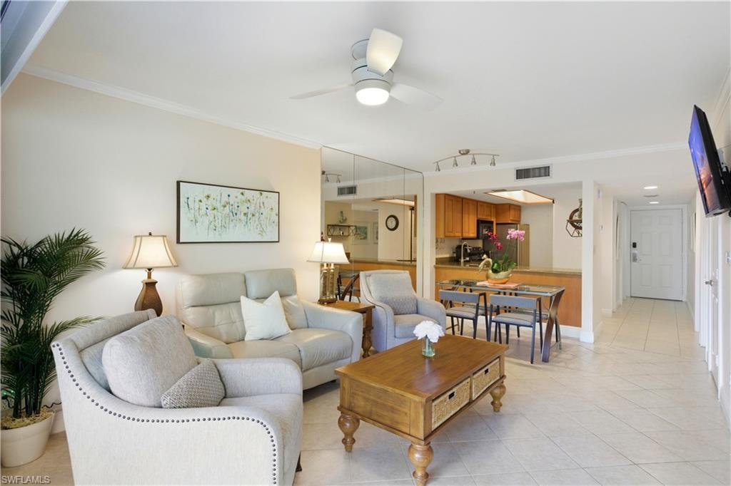 Image 2: Living area featuring light tile patterned floors, crown molding, and ceiling fan