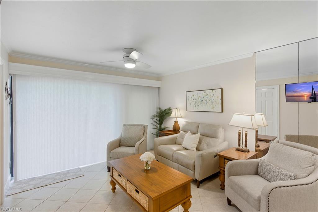 Image 3: Living room featuring light tile patterned flooring, ornamental molding, and a ceiling fan