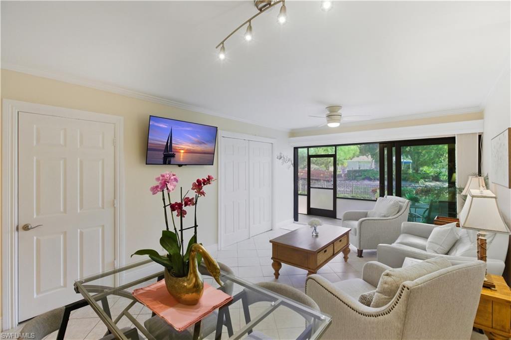 Image 4: Living area with tile patterned flooring, crown molding, and a ceiling fan