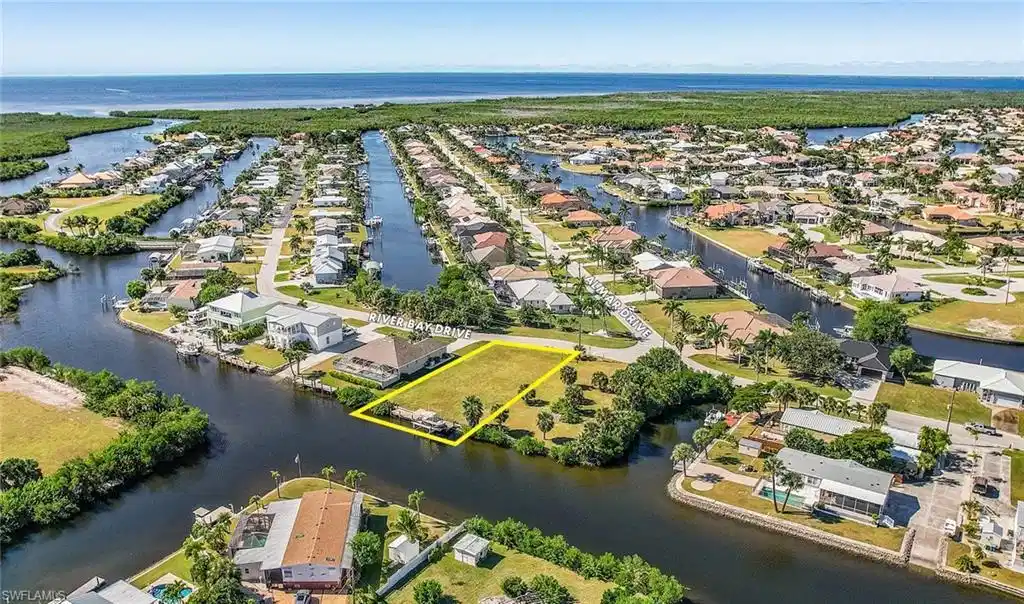 Image 1: Aerial perspective of suburban area featuring a large body of water and property boundaries highlighted