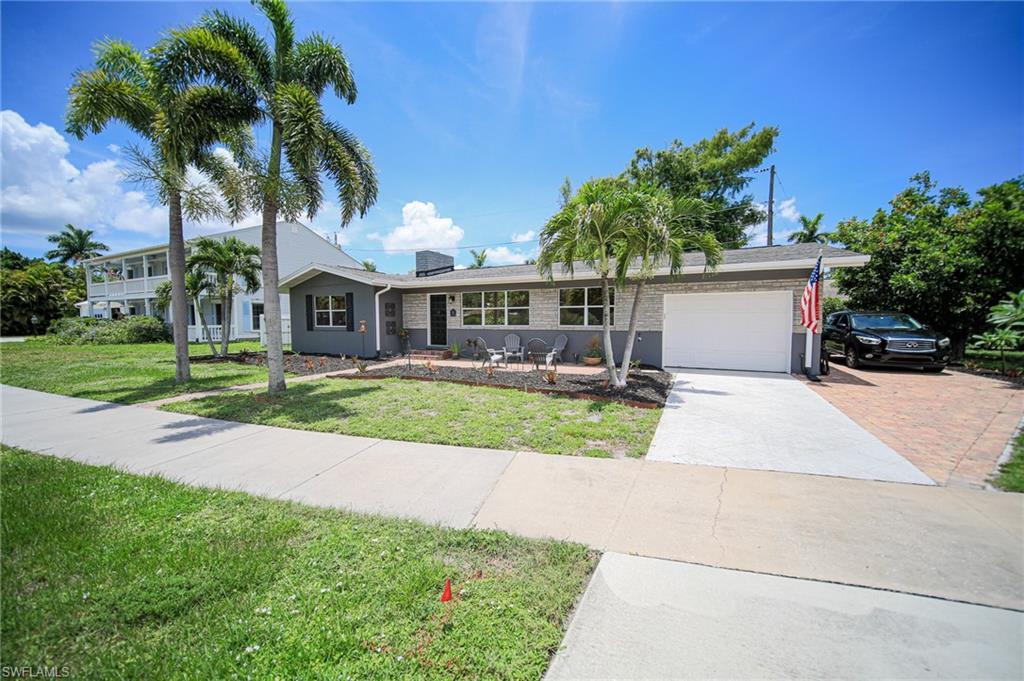 Image 2: Single-story residence featuring a gray and white exterior with a white garage door