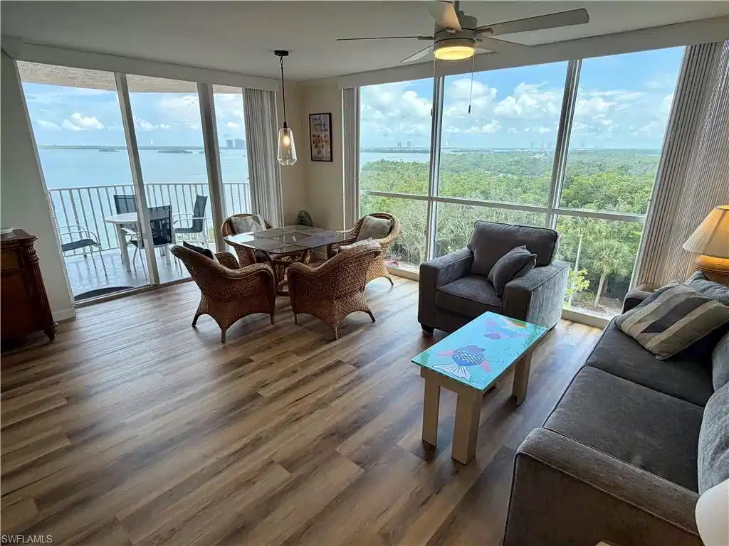 Image 1: Expansive living area with wood-finish flooring and panoramic window walls