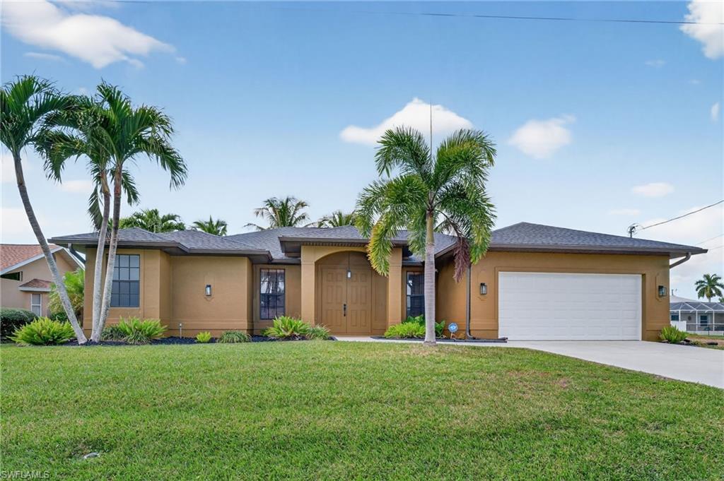 Image 1: Front with lush landscaping and beds
