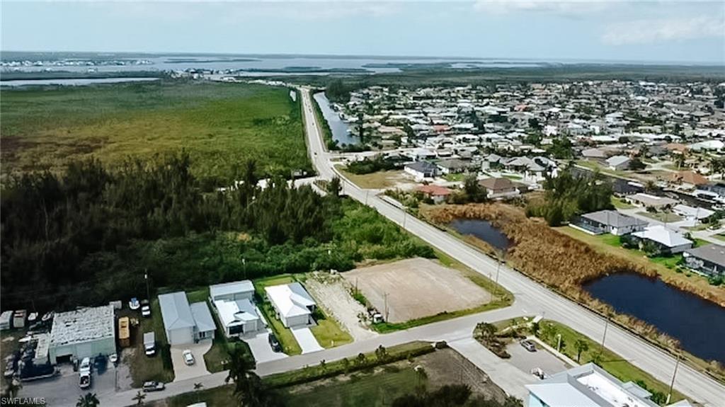 Image 3: Aerial perspective of suburban area featuring a nearby body of water