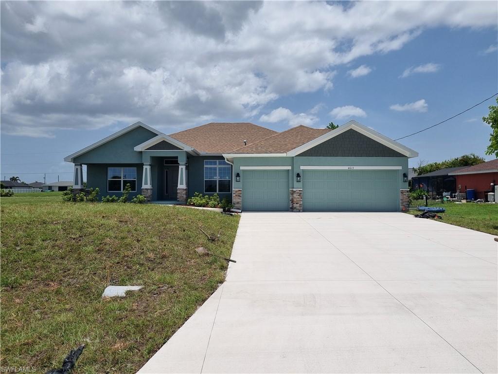 Image 2: Craftsman inspired home featuring a garage, stone siding, a front yard, and driveway