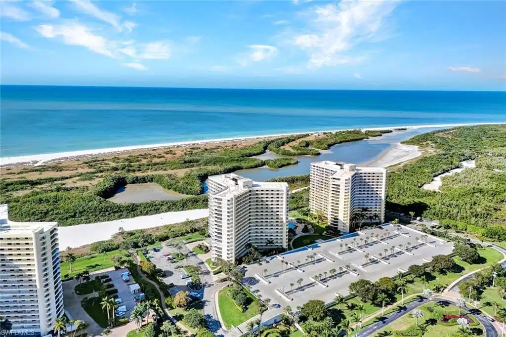 Image 1: Drone / aerial view of unending shoreline and apartment complex / building