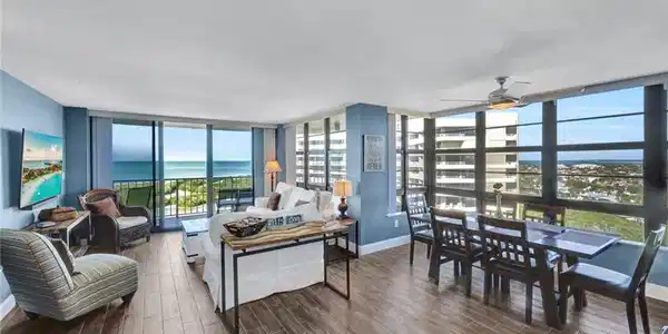 Image 4: Living area featuring dark wood-style floors, floor to ceiling windows, and a ceiling fan