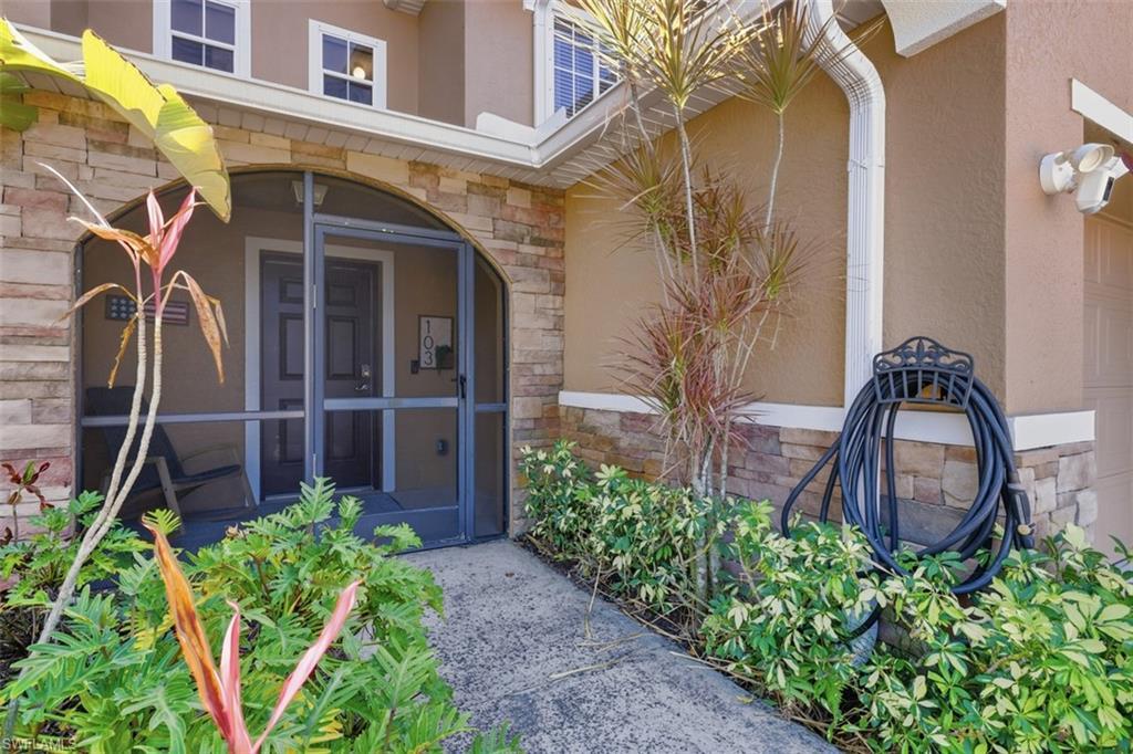 Image 2: Entrance to property with stone siding, stucco siding, and a sunroom