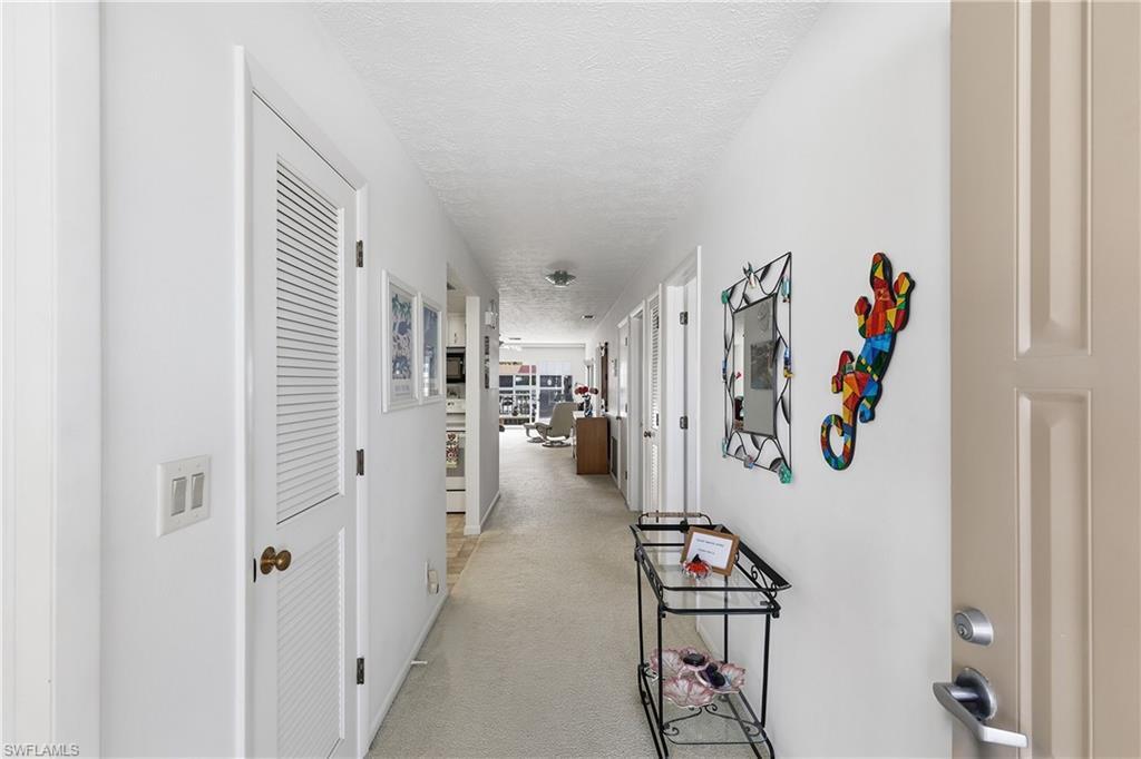 Image 4: Hallway with a textured ceiling and light carpet
