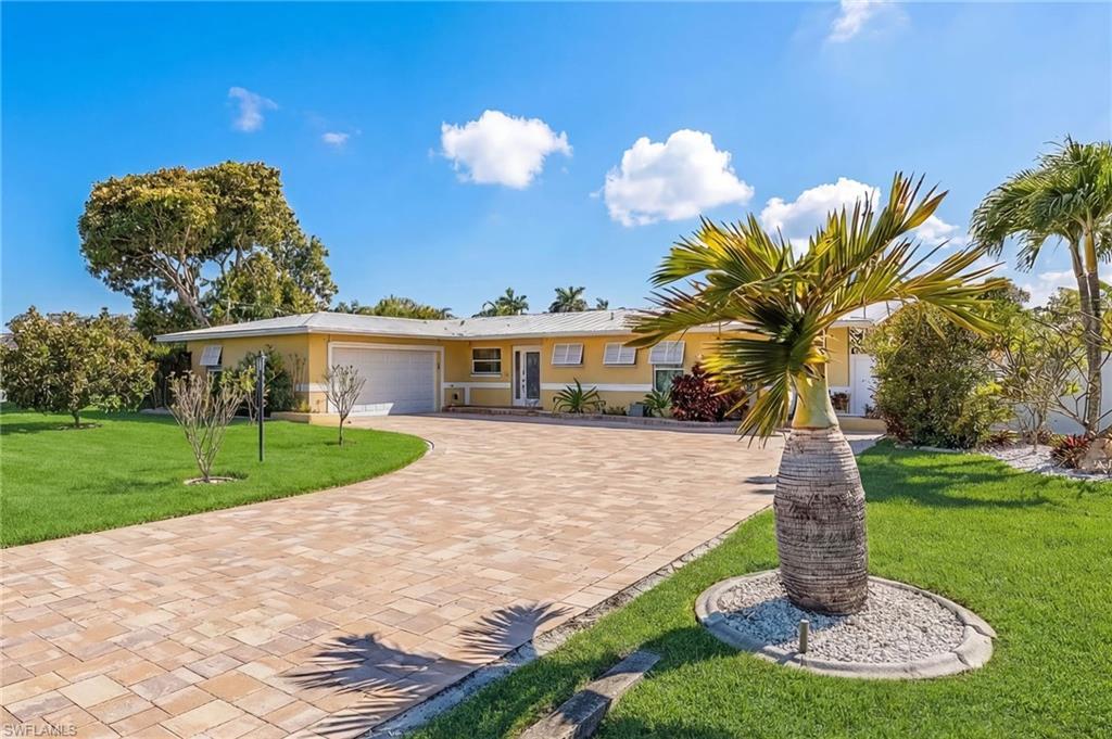Image 2: Ranch-style house featuring a front yard, stucco siding, an attached garage, and decorative driveway
