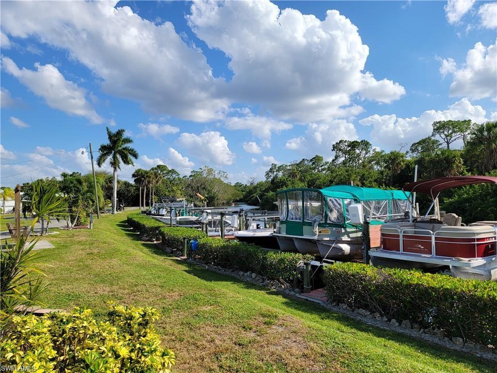 Image 1: View of community featuring a dock, a lawn, view of scattered trees, and boat lift