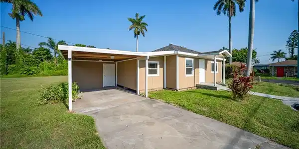 Image 3: Ranch-style home with a front yard, concrete driveway, and an attached carport