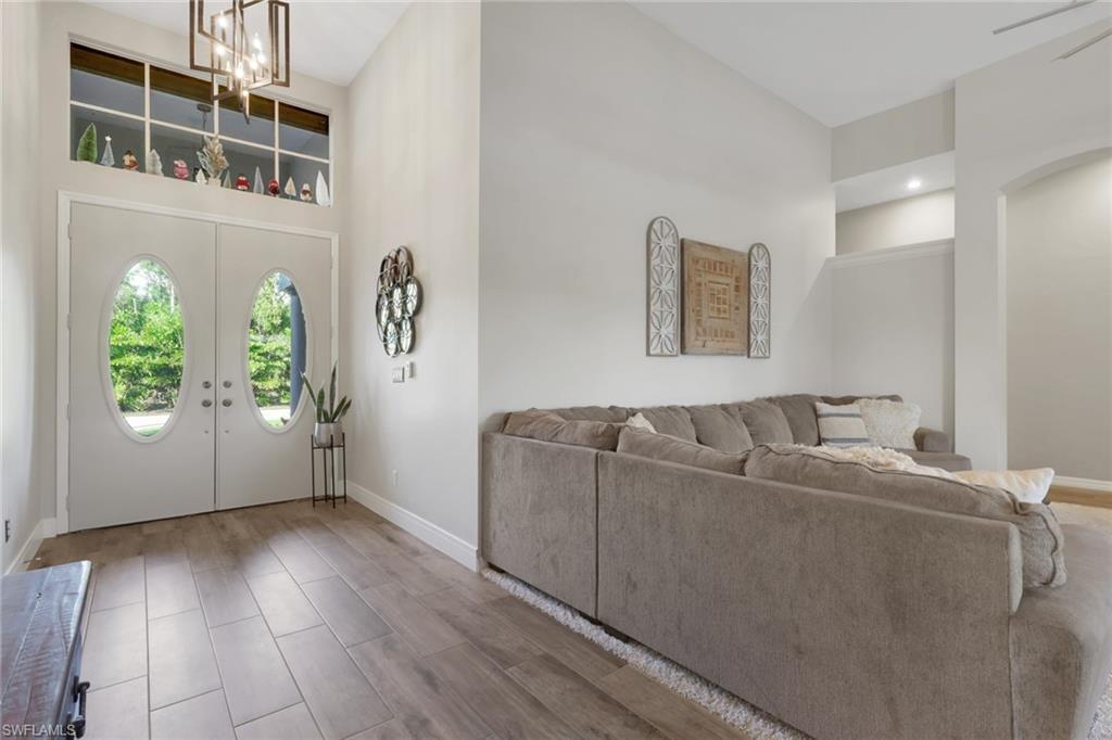 Image 3: Entryway with a towering ceiling, french doors, wood tiled floors, and a chandelier