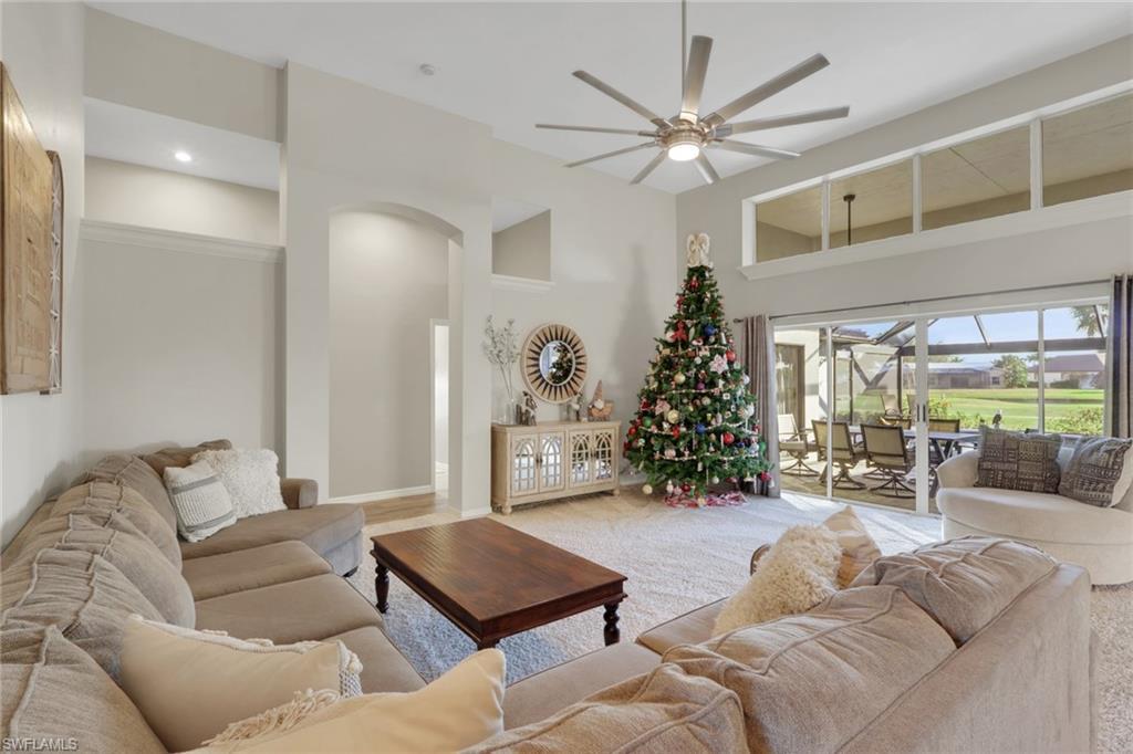 Image 4: Carpeted living room featuring a ceiling fan and a towering ceiling