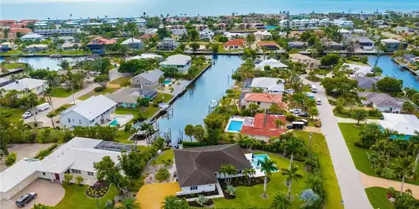Image 2: Aerial view of residential area with a large body of water