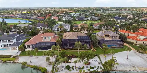 Image 3: This breathtaking aerial perspective captures the grandeur of the residence and showcases the exquisitely landscaped private beach, revealing the exceptional beauty and thoughtful design of the entire waterfront setting.