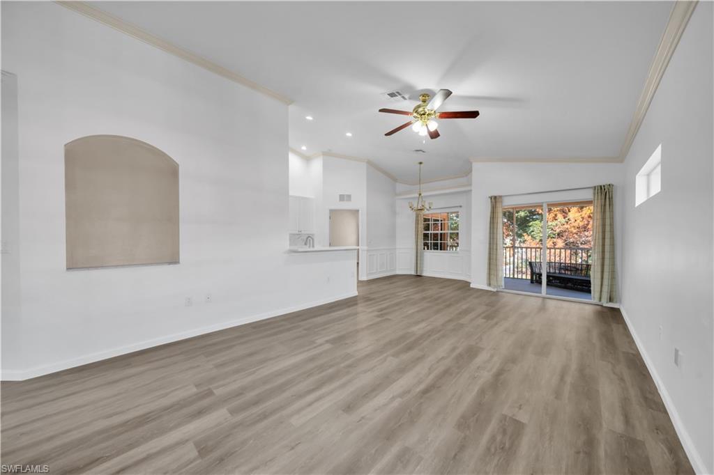 Image 4: Unfurnished living room with ornamental molding, vaulted ceiling, light wood-style flooring, ceiling fan, and hanging lights