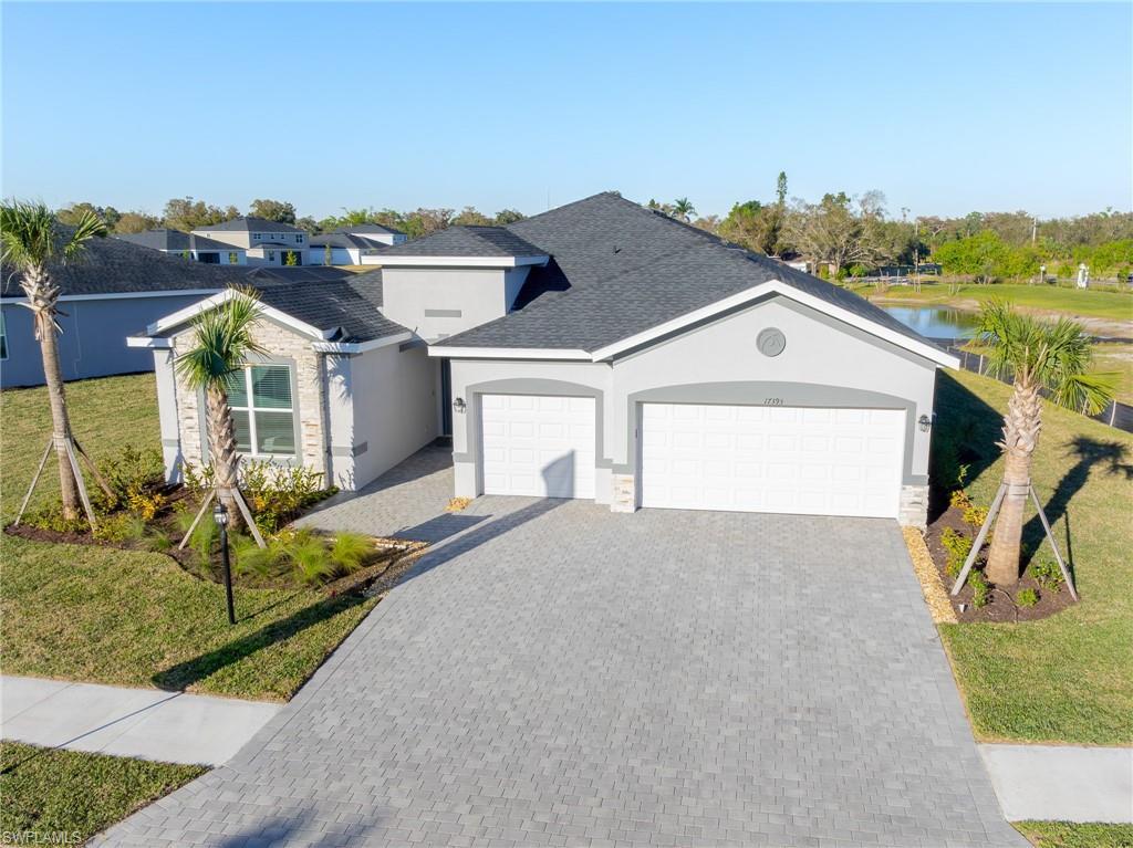 Image 2: Single story home with a front yard, a garage, decorative driveway, and stucco siding