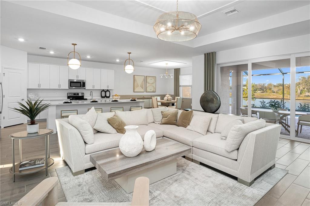 Image 4: Living area featuring a water view, a chandelier, light wood-style floors, and recessed lighting