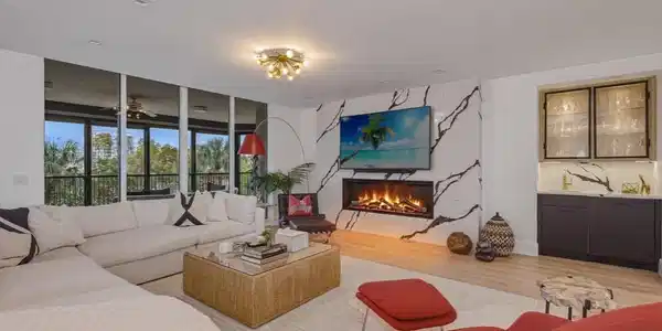 Image 2: Living area featuring Legno Bastone wood finished floors, a fireplace with marble surround, and a coordinating wet bar