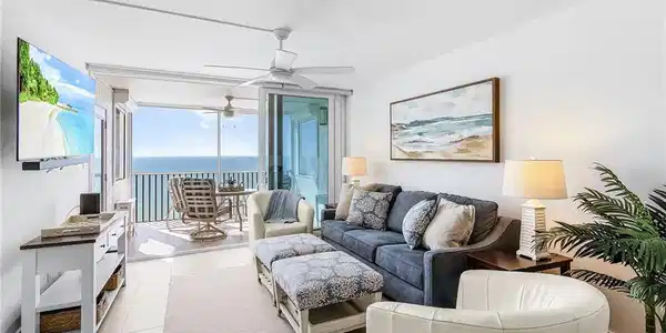 Image 2: Living room has a new sleeper sofa couch plus IMPACT SLIDERS. Located on the screened lanai, there are also side shutters. See how the wide plank long tiles go through the screened lanai!