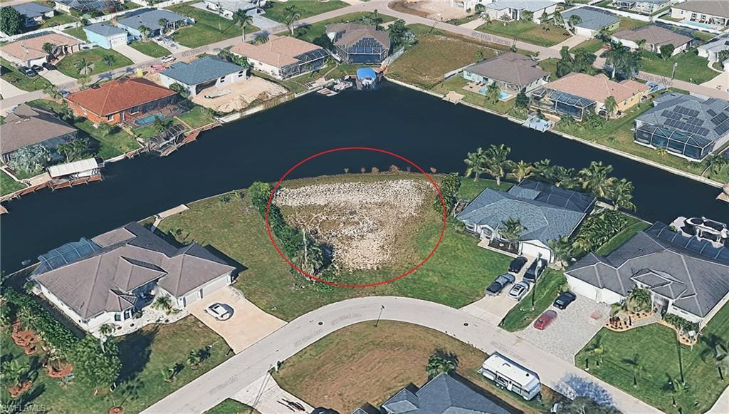 Image 2: Aerial view of residential area featuring a nearby body of water