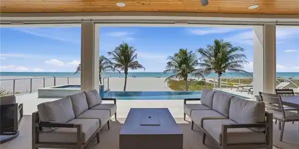 Image 2: View of patio / terrace featuring outdoor lounge area, a ceiling fan, a water view, and an in-ground hot tub - Virtually Edited Image