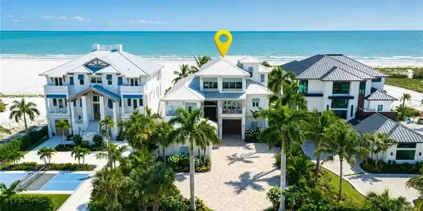 Image 4: Luxurious beachfront home showcasing three architecturally distinct residences set across manicured grounds  - Virtually Edited Image