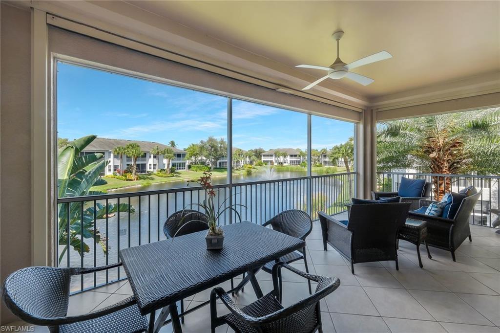 Image 3: Screened lanai overlooking the peaceful lake and water feature, offering the perfect setting for morning coffee or evening relaxation.