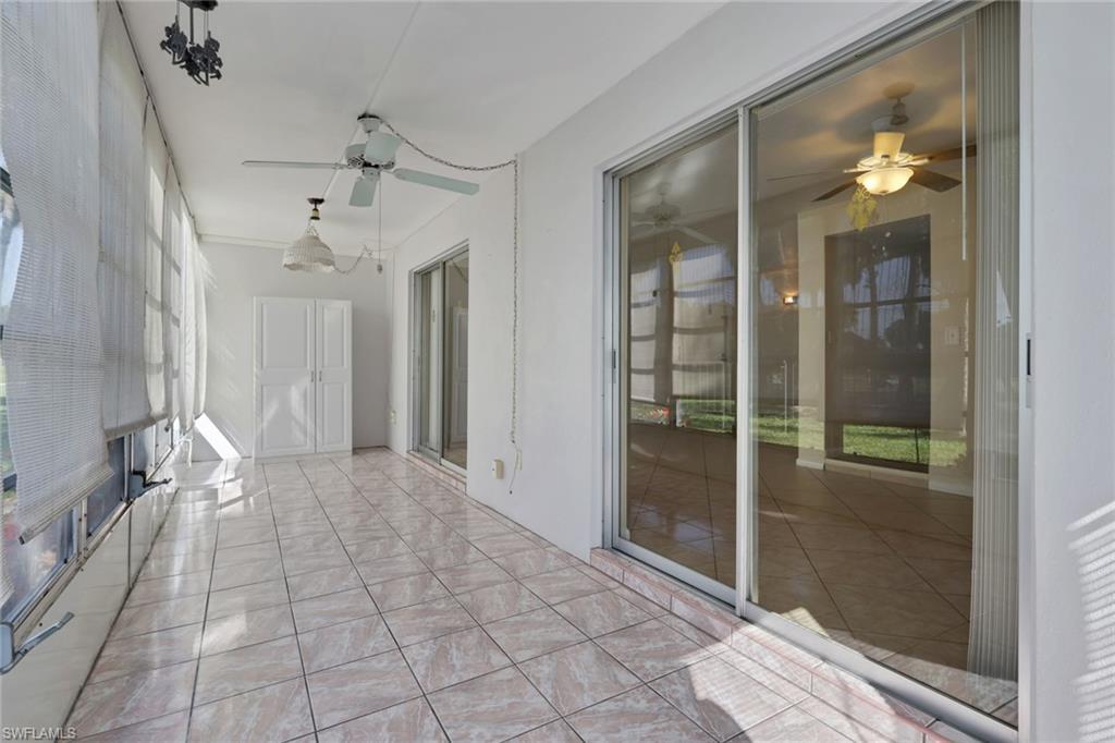Image 3: Enclosed sunroom featuring a full wall of windows, tile flooring, a ceiling fan, and access to the exterior