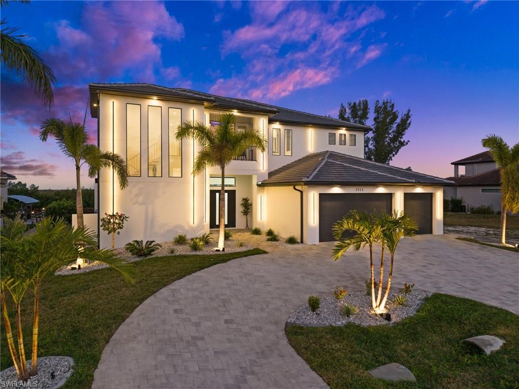 Image 1: Modern home with a yard, stucco siding, driveway, french doors, and a garage