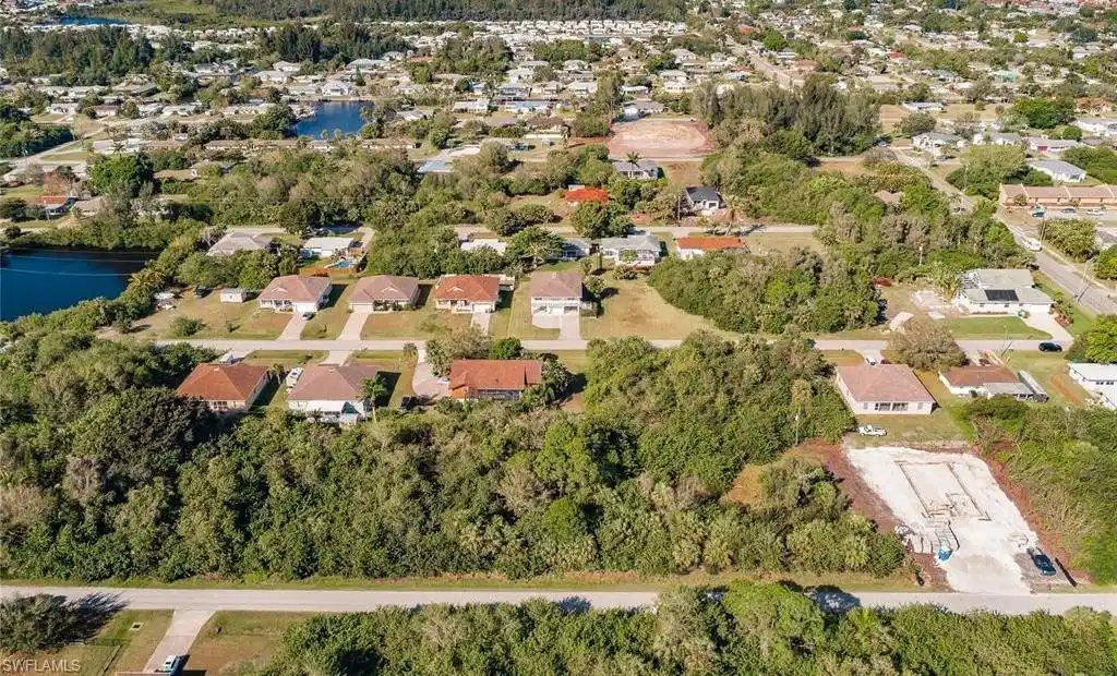 Image 1: Aerial perspective of suburban area with a nearby body of water