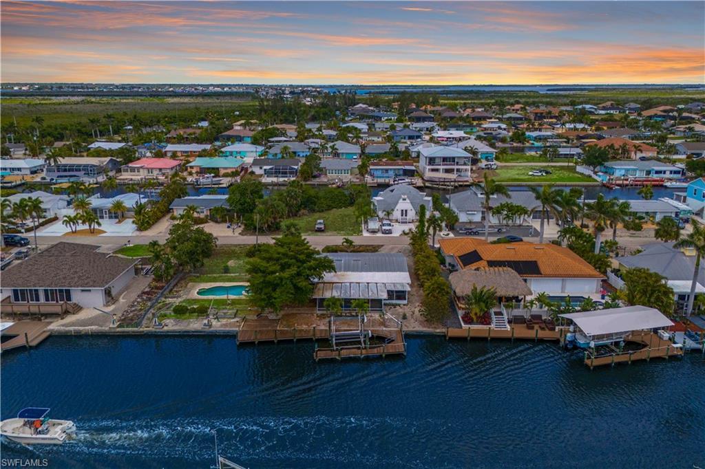 Image 3: This aerial view offers a clear sense of the spacious lot, with the pool area and dock providing an ideal layout for waterfront living, giving you direct access to the water for boating and outdoor enjoyment.