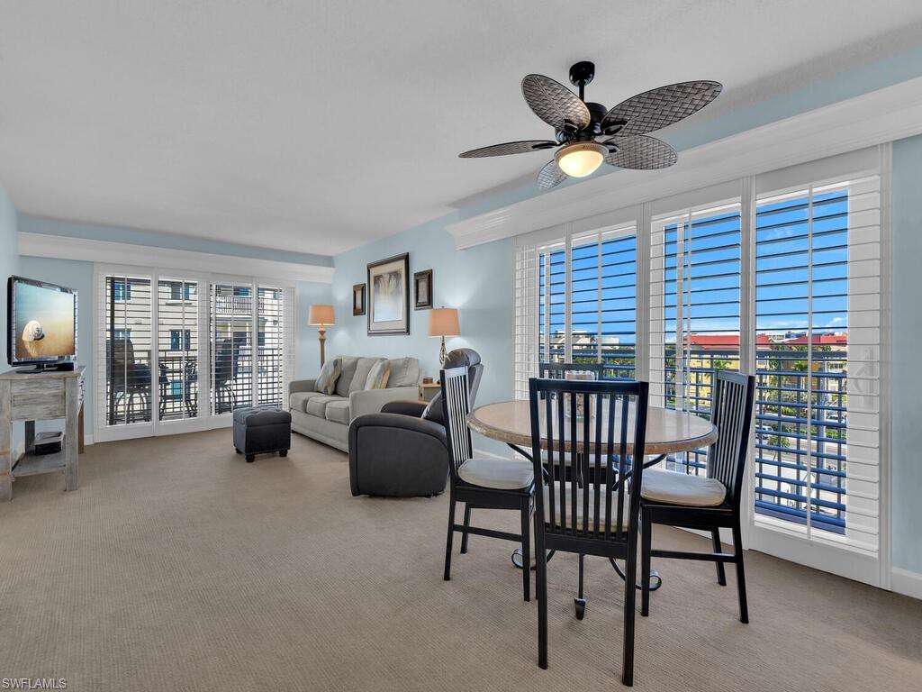 Image 3: Dining room with light colored carpet and ceiling fan