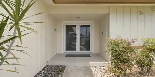 Image 2: Entryway with concrete path, dual glass-paneled doors, and exterior lighting