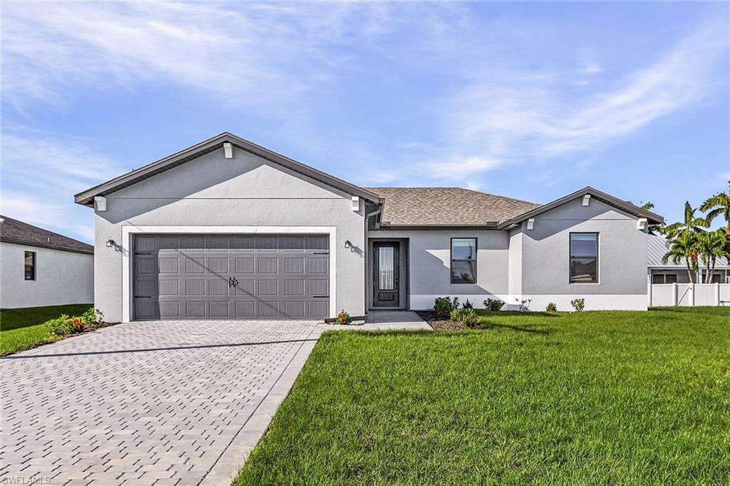 Image 1: Ranch-style house with a front yard, concrete driveway, stucco siding, and a garage