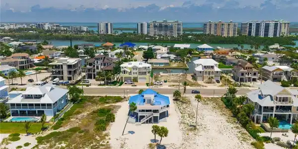 Image 4: Aerial perspective showcasing a coastal community with numerous multi-story residences - Virtually Edited Image