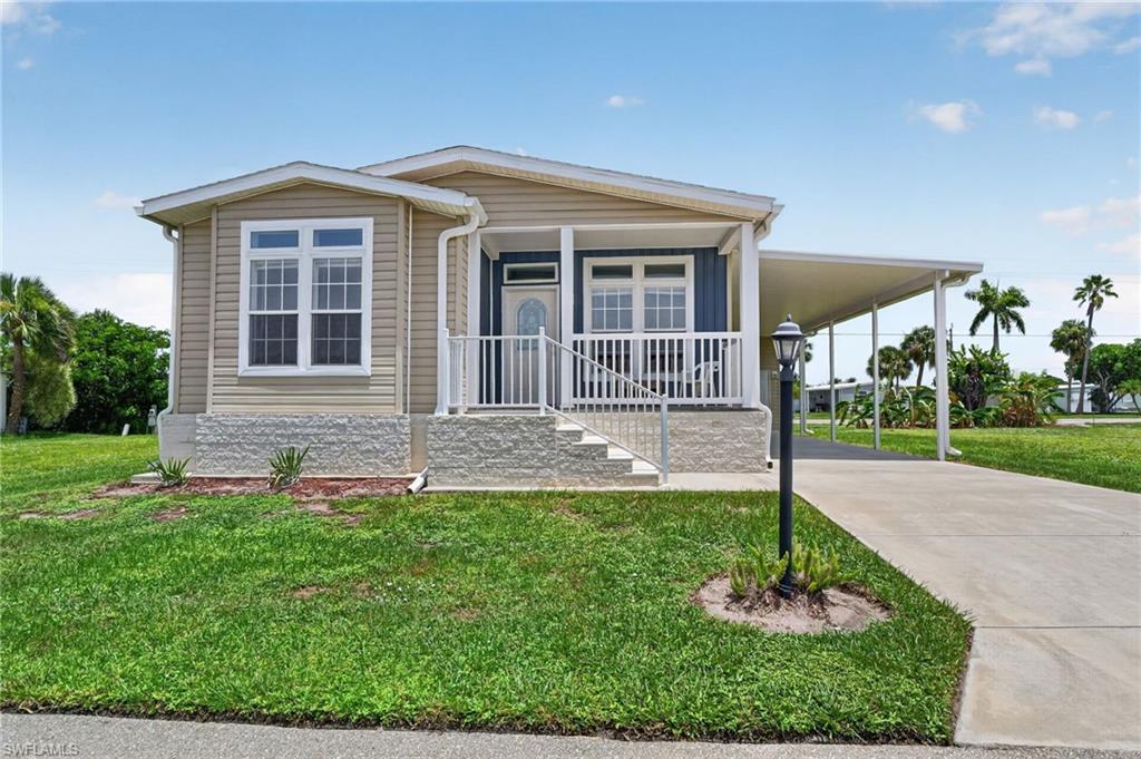 Image 1: Single-story residence featuring light-colored siding and a covered front porch