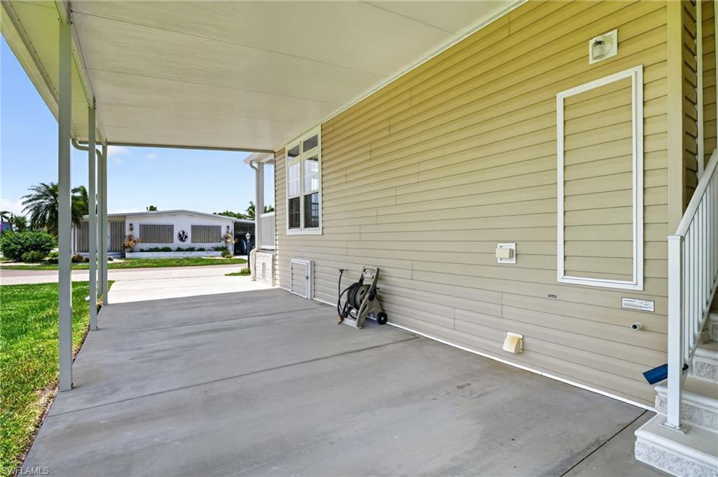Image 4: Covered carport with concrete paving, providing shelter and additional exterior space