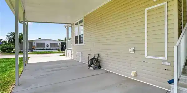 Image 4: Covered carport with concrete paving, providing shelter and additional exterior space