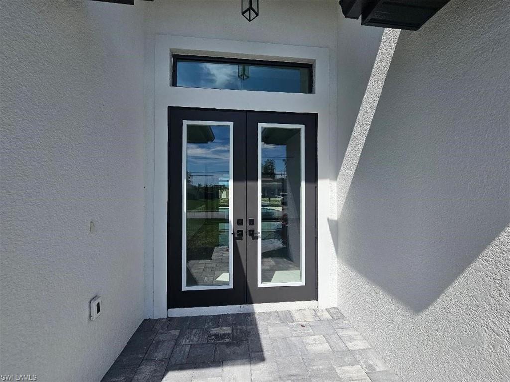 Image 4: Entrance to property with french doors and stucco siding