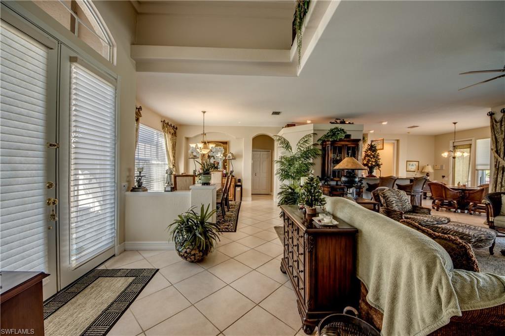 Image 4: Living room with suspended lighting, arched walkways, healthy amount of natural light, and light tile patterned floors