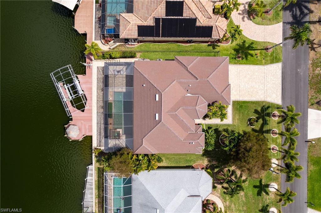 Image 4: Aerial view from above the home. There is a boat lift cover stored in garage.