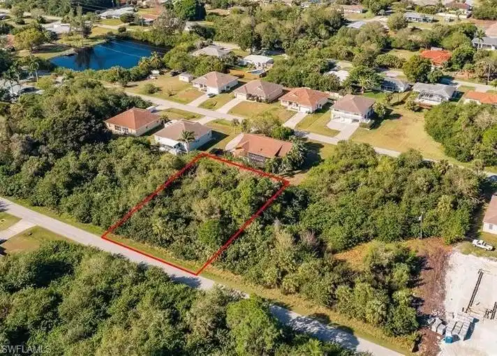 Image 1: Aerial view of residential area with property boundaries highlighted and a large body of water