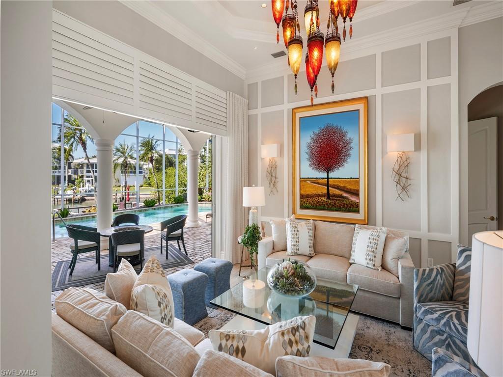 Image 3: Living area with a decorative wall, crown molding, and arched walkways