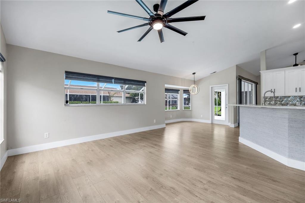 Image 2: Family Room  featuring , vaulted ceilings Luxury Vinyl Plank Flooring, and a contemporary ceiling fan