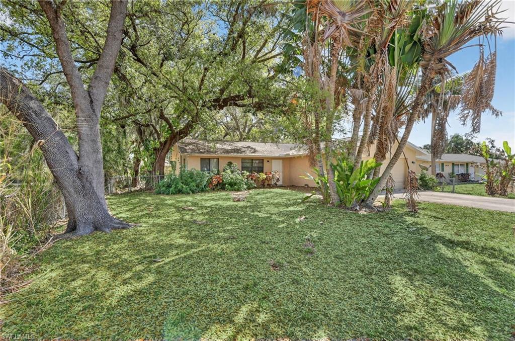 Image 1: Ranch-style house with stucco siding, a garage, and concrete driveway