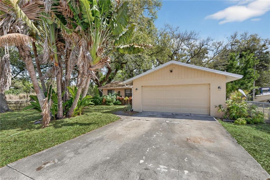 Image 2: View of front facade featuring stucco siding, concrete driveway, and an attached garage